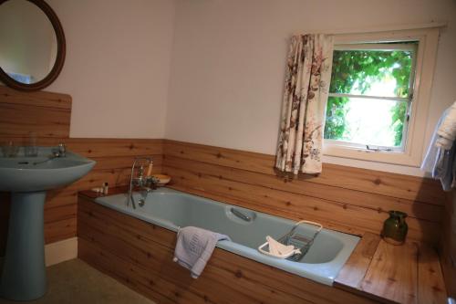 MoyardにあるCrocnaraw Country Houseのバスルーム(バスタブ、シンク付)、窓が備わります。