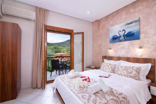 a bedroom with a bed with a view of a balcony at Pension Maria in Astris