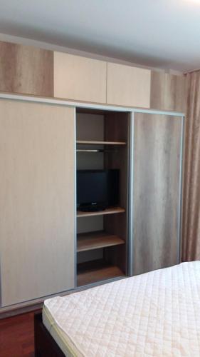 コンスタンツァにあるSea View Noblesse Apartment Constantaのベッドルーム1室(ベッド1台、キャビネット内のテレビ付)