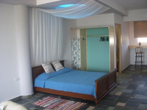 a bedroom with a bed with a blue comforter at Seascape Apartment in Faliraki