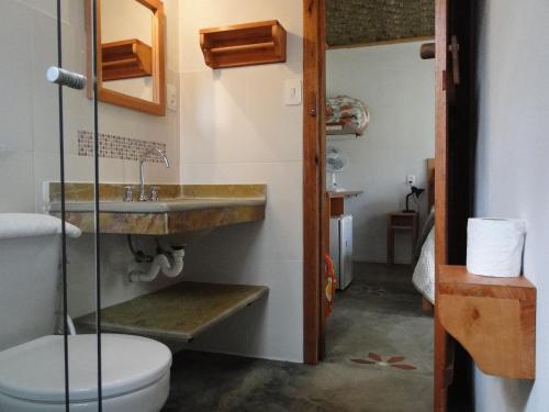 uma casa de banho com um lavatório e um WC em Pousada Do Pequi em São Gonçalo do Rio das Pedras