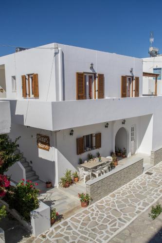 a white building with a patio and a table at Eleni's Rooms in Antiparos Town