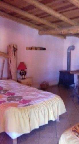 a bedroom with a bed and a red lamp on a table at Cabañas Margarito in Areponapuchi