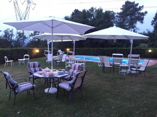 a group of tables and chairs with umbrellas at Casali Romei in Sarzana