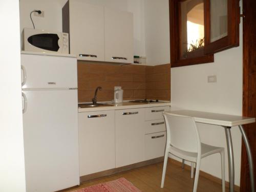 una cucina con frigorifero bianco e tavolo di Cortile Antico a Trapani
