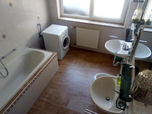 ein Badezimmer mit zwei Waschbecken, einer Badewanne und einem WC in der Unterkunft Haus Renarth - Michaela Pro in Kitzeck im Sausal