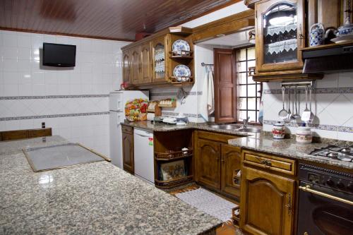 a kitchen with wooden cabinets and a stove top oven at Casa De Cacheiro in Silleda