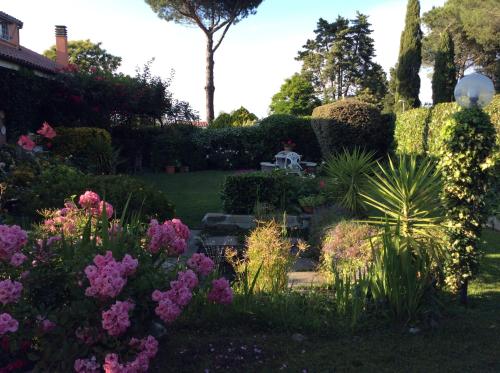 a garden with flowers and a table in the background at Villa Nanda a 15 minuti da Roma piscina esclusiva , villa nella natura in Formello