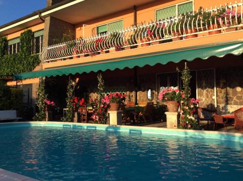 a hotel with a swimming pool in front of a building at Villa Nanda a 15 minuti da Roma piscina esclusiva , villa nella natura in Formello