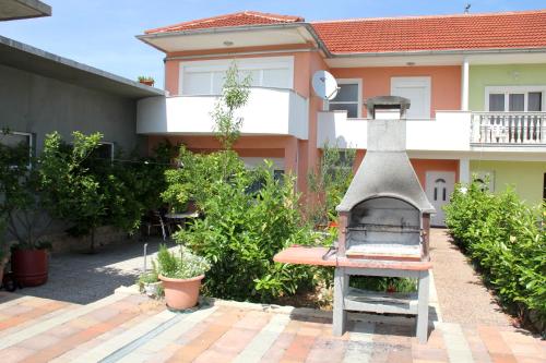 a backyard with a grill in front of a house at Apartment Bura in Šibenik