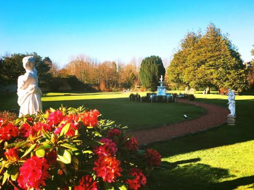 a statue in a park with flowers and a fountain at The Ennerdale Country House Hotel ‘A Bespoke Hotel’ in Cleator