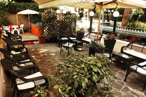 a group of chairs and tables with plants on a patio at Hotel Santiago in Milano Marittima