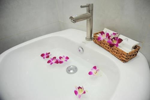 a bathroom sink with a basket of flowers on it at My Anh 120 Central Saigon Hotel Ben Thanh Market in Ho Chi Minh City