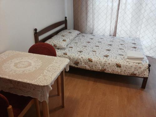 een kleine slaapkamer met een bed en een tafel bij Deima in Nida