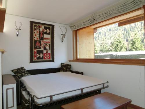 a small room with a bed and a window at Bilocale Alberti - Gran Baita in Madonna di Campiglio