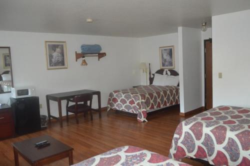 a hotel room with two beds and a table at American Elite Inn in Hazard