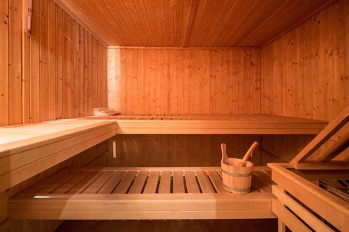 a wooden sauna with a bucket in the middle at T3 Alpenhotel Garfrescha in Sankt Gallenkirch