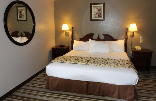 a hotel room with a large bed and a mirror at American Elite Inn in Hazard