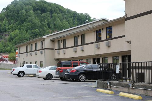 a building with cars parked in a parking lot at American Elite Inn in Hazard