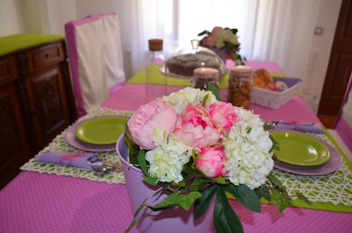 a purple table with a bouquet of pink and white flowers at up in Carosino
