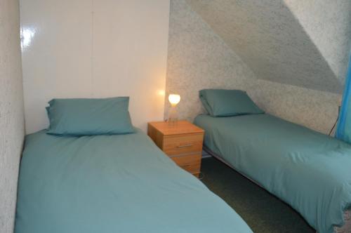2 Betten nebeneinander in einem Zimmer in der Unterkunft Hazel Bank Villa Apartment in Dunoon