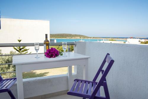 a white table with a bottle of wine and two chairs at Sirene Villas in Dhiakofti