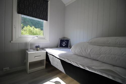 a small bedroom with a bed and a window at Steinshølen Holiday Home in Flåm