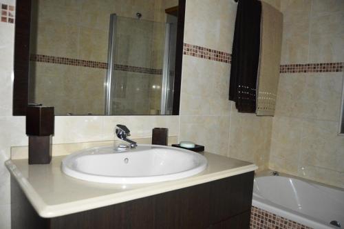 a bathroom with a sink and a mirror and a tub at Matosinho's Palace in Matosinhos