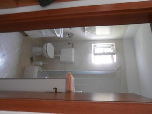 einen Spiegel im Bad mit Waschbecken und Fenster in der Unterkunft Apartment Maglica in Zlarin