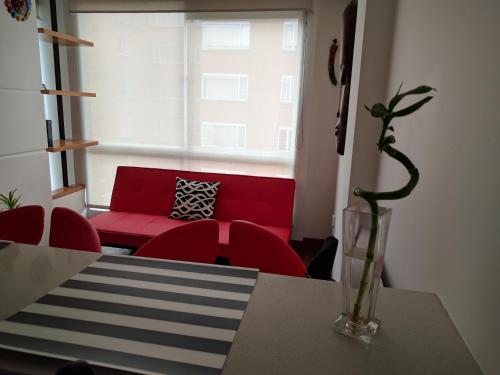 uma sala de estar com um sofá vermelho e uma mesa em Chic space by Unicentro em Bogotá