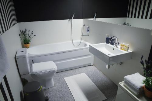 een witte badkamer met een toilet en een wastafel bij Apartament White in Śrem