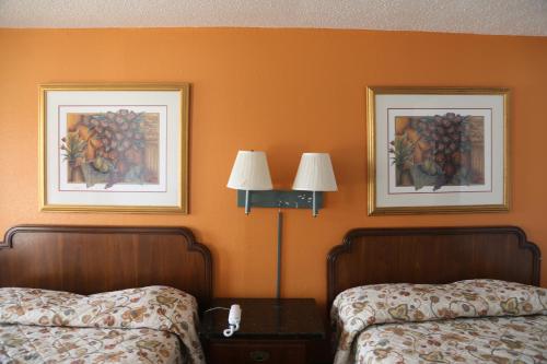 2 Betten in einem Hotelzimmer mit 2 Bildern an der Wand in der Unterkunft Sherman Inn in Sherman