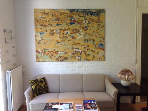 a living room with a couch and a painting on the wall at Davaa's Bed & Breakfast in Randers