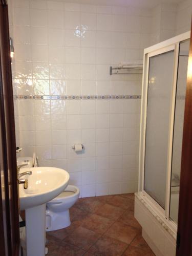 a bathroom with a toilet and a sink and a shower at Pension Meson Paz in Puentedeume
