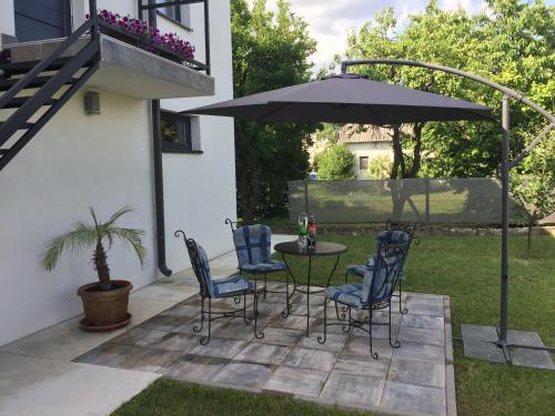 a patio with a table and chairs under an umbrella at Apartmani Mila in Laktaši