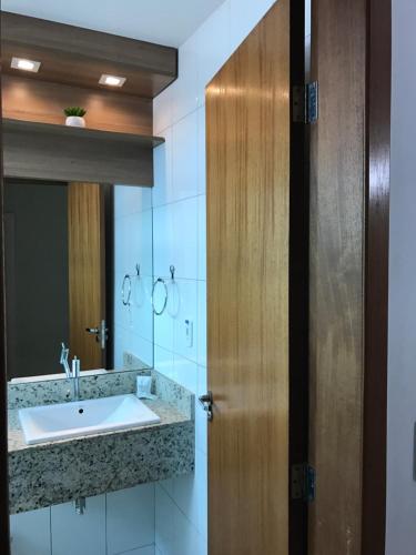 baño con lavabo y puerta de madera en Hotel Ecos Classic, en Porto Velho