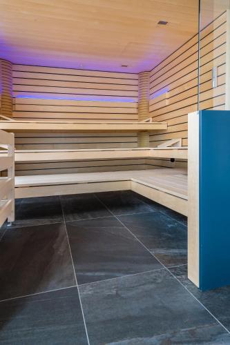a sauna with wooden seats in a room at Hotel Restaurant Zur alten Gasse in Bellwald