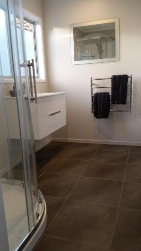 a bathroom with a sink and a mirror at Woodbury Farm B&B in Takanini