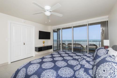 a bedroom with a blue bed with a view of the ocean at Sea Vista in South Padre Island