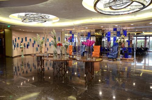 a lobby with two tables with vases of flowers on them at Gold Majesty Hotel in Bursa