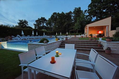 a white table and chairs next to a swimming pool at Apartments Tena in Poreč