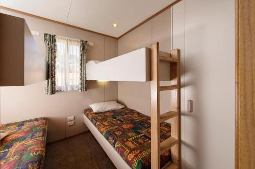 A bed or beds in a room at Rainbow Pines Tourist Caravan Park