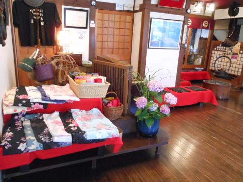 a room with a bed and a table with flowers at Noren Yado Meigetsu in Tsuwano