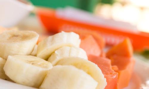 a pile of sliced bananas and oranges on a plate at Hostal Pelikan Taganga in Taganga