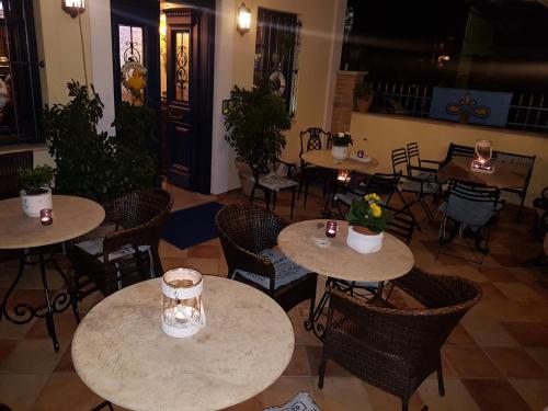 an empty restaurant with tables and chairs with plants at ''EPAVLIS boutique GALAXIDI'' in Galaxidhion