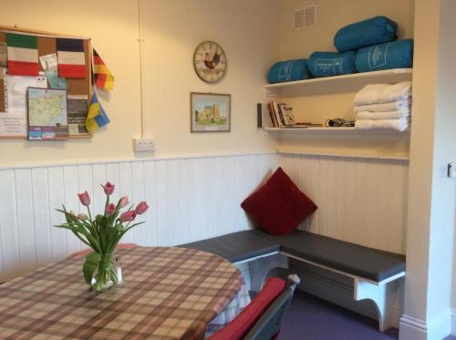a dining room with a table and a vase of flowers at Bower Pods in Bowermadden