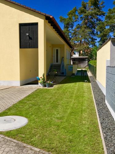 a house with a lawn in front of it at Ferienwohnung Föhrenweg in Neumarkt in der Oberpfalz