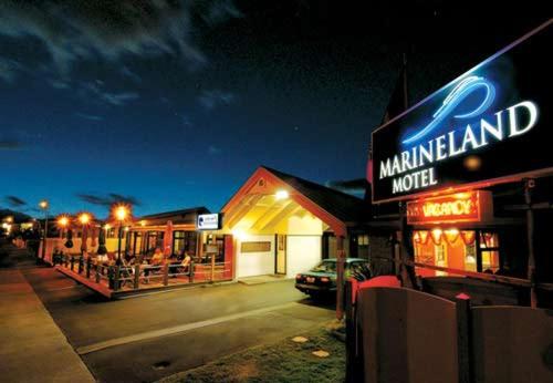a restaurant with a sign on the side of a street at Marineland Beachfront Accommodation in Napier