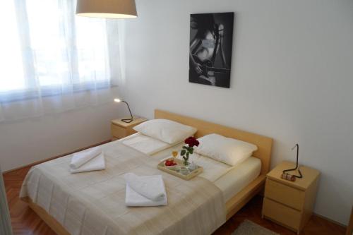 een slaapkamer met een bed met witte lakens en bloemen erop bij Apartment Playa in Novigrad Istria