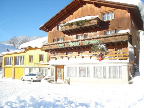 a building with a sign on it in the snow at Hotel Alpina in Unterwasser